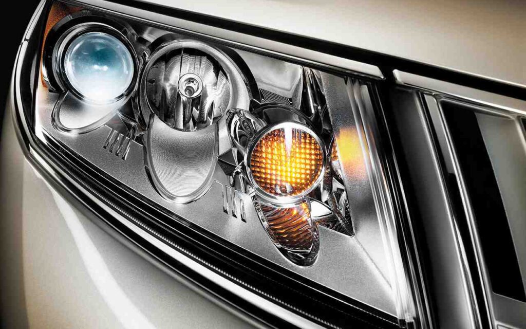 Close-up of a modern car headlight with amber indicator, showcasing sleek design and technology.